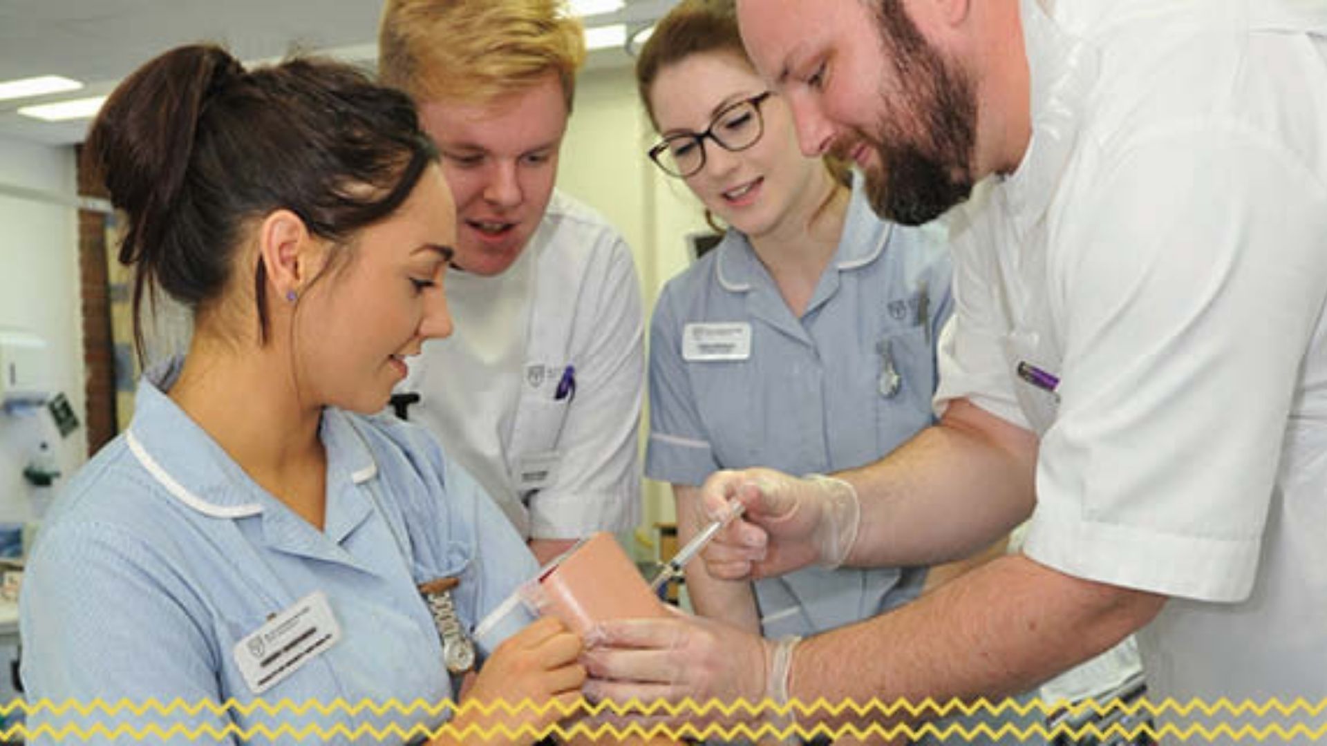 A student nurse giving an injection to a dummy arm in front of 3 other students